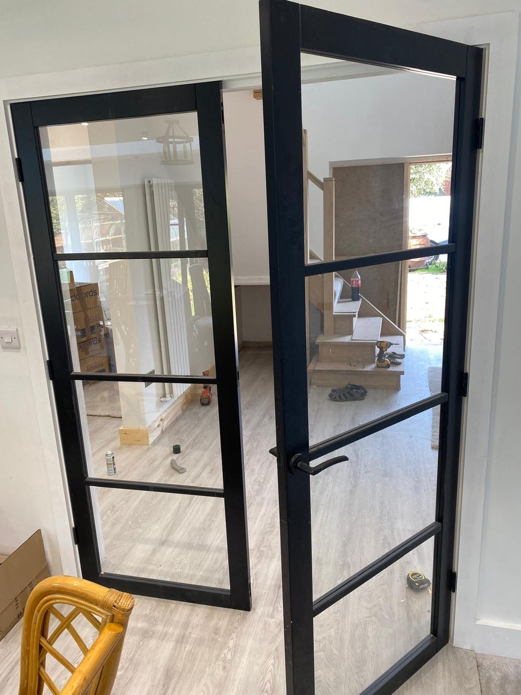 Pair of black-framed glazed internal doors standing open onto a bright room